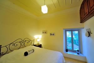 a bedroom with a white bed and a window at Hydra Optima in Hydra