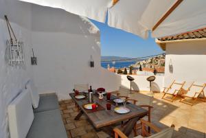 a patio with a table and a view of the ocean at Hydra Optima in Hydra