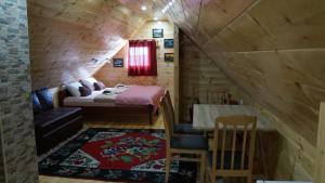 a small room with a bed and a table in a cabin at Apartments Millenium in Žabljak