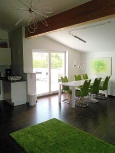 a dining room with a white table and green chairs at Ferienwohnung zum Kletterturm in Kaufbeuren