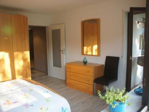 a bedroom with a bed and a dresser and a chair at Ferienwohnung Mayer in Albstadt