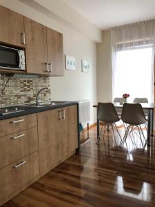 a kitchen with wooden cabinets and a table with chairs at Evička Penzion in Veľký Meder