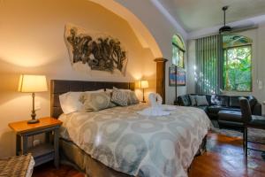 a bedroom with a large bed and a couch at Hacienda Xcaret in Playa del Carmen