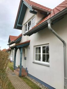 uma casa branca com um telhado vermelho em Ferienhäuser Liethmann Haus 3 W2 em Timmendorf