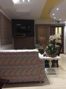 un soggiorno con divano e tavolo con fiori di Hotel do Lago a Toledo