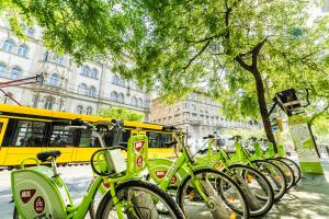 ブダペストにあるMegszűnt - Vintage Garden Apartment with Terrace & Saunaの黄色いバスの横に停まった緑の自転車