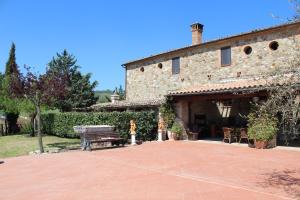 a stone building with a bench and a table at Country House La Collina di Bargiano - Casa Raffaella in Allerona
