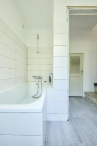 Baño blanco con bañera y lavamanos en The Beach House, en Praia da Barra