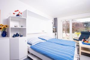 ペルツァーハケンにあるNeuKlosterhof App. 19の白いベッドルーム(青いシーツ付きのベッド1台付)