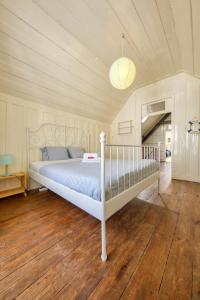 een slaapkamer met een wit bed in een kamer bij The Beach House in Praia da Barra
