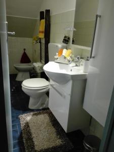 a bathroom with a white sink and a toilet at Dedo B&B in Terlizzi