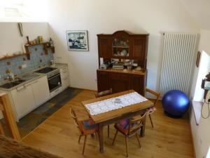 eine Küche mit einem Tisch und Stühlen im Zimmer in der Unterkunft Feriengaleriewohnung Im Denkmal Stilvoll-Komfortabel Baubiologisch in Erlenbach