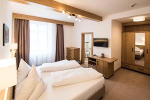 Cette chambre comprend deux lits et une télévision. dans l'établissement Hotel Post, à Sankt Anton am Arlberg