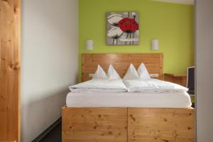 a bedroom with a bed with a wooden headboard at Hotel-Cafe Demling in Randersacker