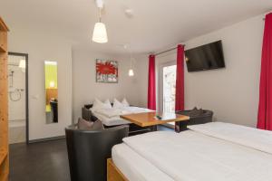 a hotel room with two beds and a table and chairs at Hotel-Cafe Demling in Randersacker