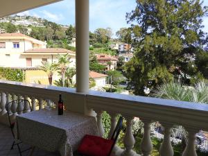 een balkon met een tafel en uitzicht op de stad bij Villa Emma in Ospedaletti