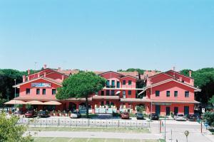 a group of large red buildings in a parking lot at Residence Corallo in Rosolina Mare