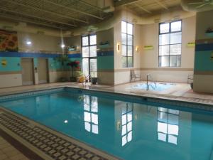 a swimming pool with blue water in a building at Baymont by Wyndham Fargo in Fargo