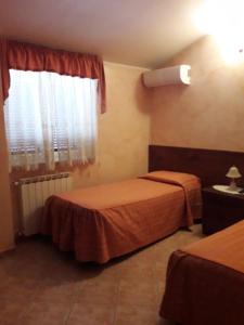 Habitación de hotel con 2 camas y ventana en la Campagnola, en Cerveteri