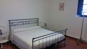 a bedroom with a bed with white sheets and a window at Agriturismo Frigionaia in Carmignano