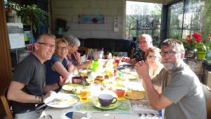 a group of people sitting around a table eating at Chez Catherine - Chaumière Normande in Theuville-aux-Maillots +21 photos