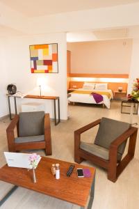 a living room with two chairs and a bed at ONOMO Hotel Abidjan in Abidjan