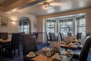 a restaurant with tables and chairs and windows at OYO Devonshire Park Hotel in Eastbourne +30 photos