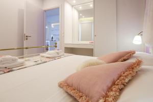 una camera con letto bianco e specchio di Cozy Home steps from old Port, Seafront & Parking a Kolymvari