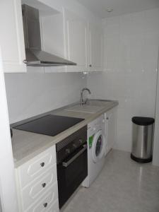cocina blanca con fregadero y lavavajillas en Apartamento en Vinaros, en Vinarós