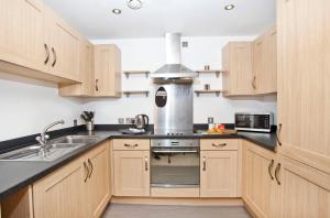 Una cocina con gabinetes de madera y un horno de estufa. en 16 John Walker House, en York 4 fotos más