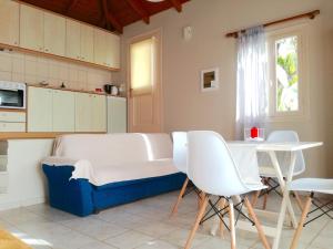 a white couch sitting in a kitchen next to a table at 12 Gods Resort in Pylos