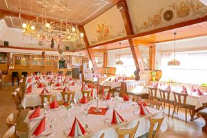 a dining room with tables and chairs with red napkins at Landgasthof Germania in Rüdesheim am Rhein