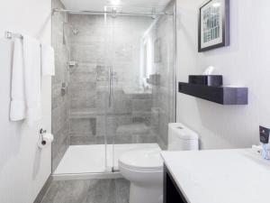 a white bathroom with a shower and a toilet at Crowne Plaza Hotel Moncton Downtown, an IHG Hotel in Moncton