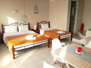 a hotel room with two beds and a table at 12 Gods Resort in Pylos