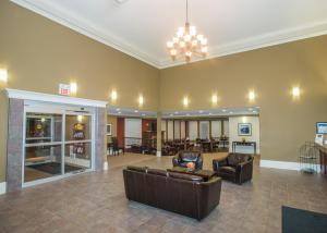 uma ampla sala de estar com um sofá e cadeiras em Lakeview Inns & Suites - Edson Airport West em Edson