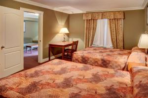 a hotel room with two beds and a desk at Lakeview Inns & Suites - Edson Airport West in Edson