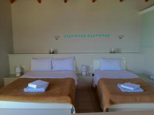 two beds sitting next to each other in a room at 12 Gods Resort in Pylos