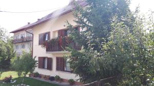 a white house with balconies and flowers on it at Apartman Petra & Tena in Slunj