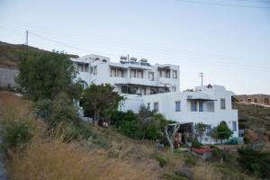 a white building on top of a hill at Captain Manos Studio Apartments in Grikos