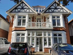 a house with two cars parked in front of it at Beach Lodge in Bournemouth