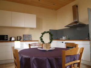 une cuisine avec une table et un chiffon violet dans l'établissement La Vayssade - Gîte de Charme - 6 pers - Piscine Jacuzzi & Truffes, à Lalbenque