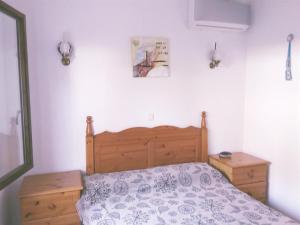 1 dormitorio con 1 cama con cabecero de madera en Casa Anna, en Denia