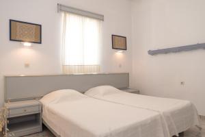 two beds in a room with a window at Captain Manos Studio Apartments in Grikos
