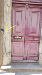 een grote roze deur met een gele pijl erop bij Studio proche Jean Moulin, location courte durée in Béziers