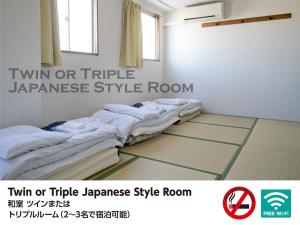a hospital room with a bed and a wall at Hotel Raizan South in Osaka