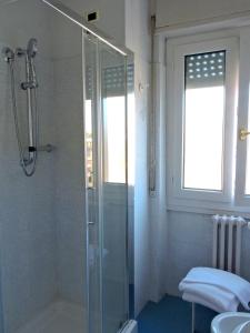 bagno con doccia in vetro e lavandino di Hotel Capri a Lesa