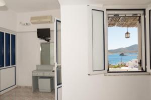 a room with a window with a view of the ocean at Captain Manos Studio Apartments in Grikos