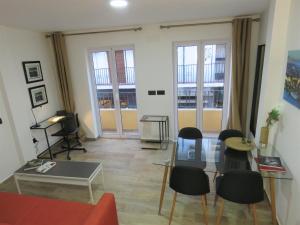 sala de estar con sofá, mesa y sillas en Living Sevilla Apartments Hércules, en Sevilla