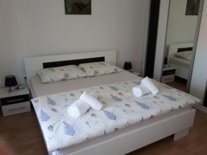 a white bed with two pillows on top of it at Apartman Petra & Tena in Slunj