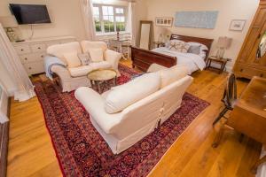 a living room with a couch and a bed at The Garden Studio in Budleigh Salterton